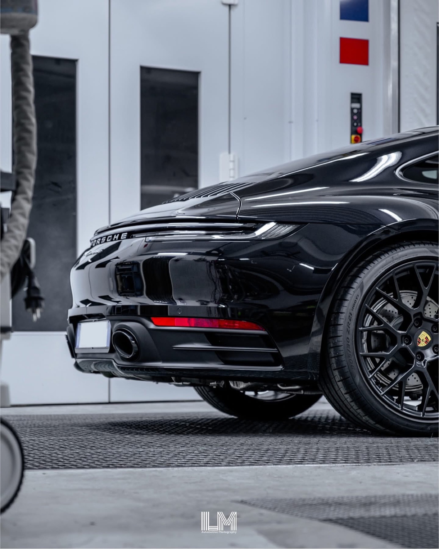 Posteriore di una Porsche 911 992 nera con cerchi neri