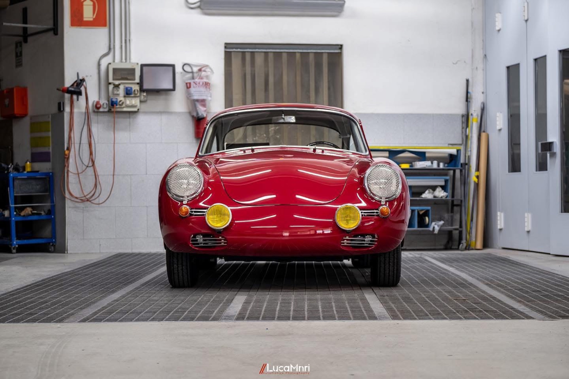 Frontale di una Porsche 356 rossa d'epoca in officina